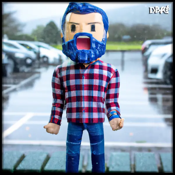 A blocky toy figure of a bearded man in a rainy car park